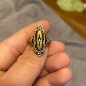 Oval shaped gold plated metal ring with a small diamond gem in the middle